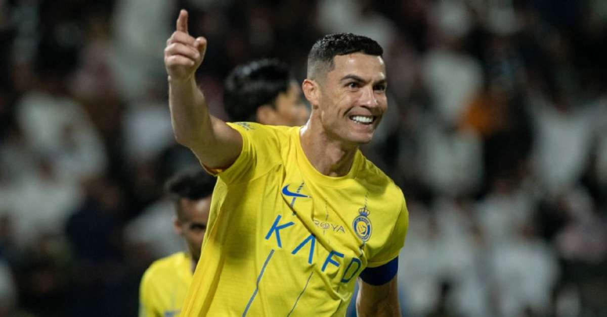 Cristiano Ronaldo pemain Liga Champion menggunakan baju warna kuning sambil tersenyum mengacungkan telunjuk