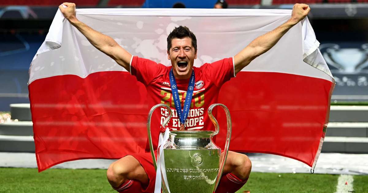Robert Lewandowski memegang bendera dan piala kemenangan di UCL