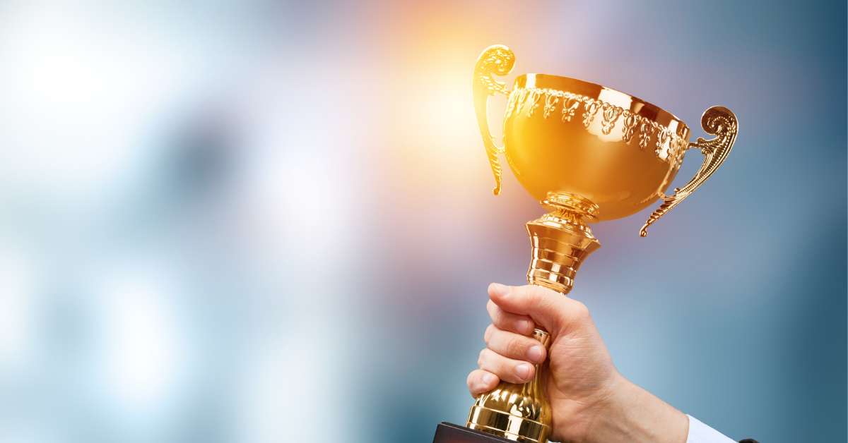 tangan memegang piala kemenangan